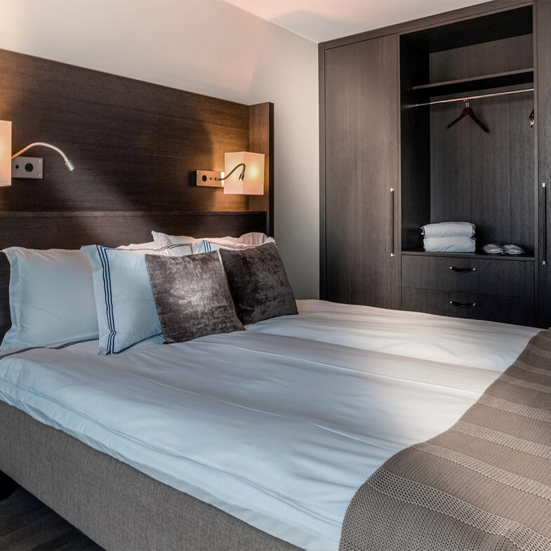 Sovrum i hotellrum med säng och garderob