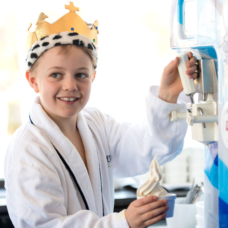 Kille med badrock vid glassmaskin.