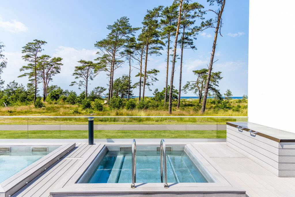 Japansk pool på terrass med hav och skog i bakgrunden